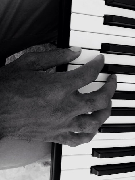 A close-up shot of the blind musician's hands playing the piano keys with passion and skill. The image emphasizes their connection to the instrument and the emotional depth of their music.