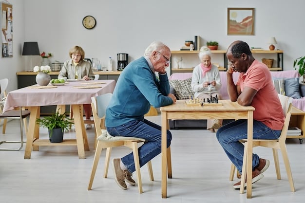 A volunteer and a senior are sitting together at a table, playing a board game and laughing. The room is bright and cheerful, and both individuals appear engaged and happy.