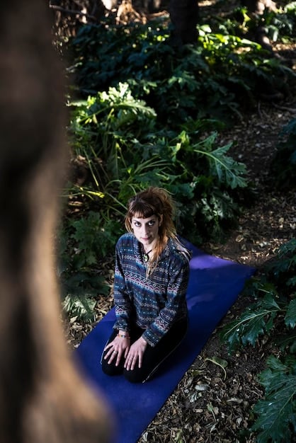A person practicing yoga outdoors in a peaceful setting, emphasizing stress reduction and mindfulness.