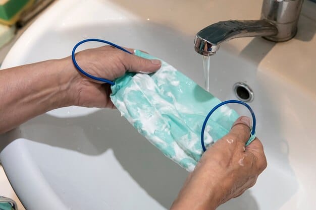A person washing a fabric face mask in a sink with mild soap and water. Focus on the action of gently cleaning the mask, with attention to the cleanliness of the surrounding environment.