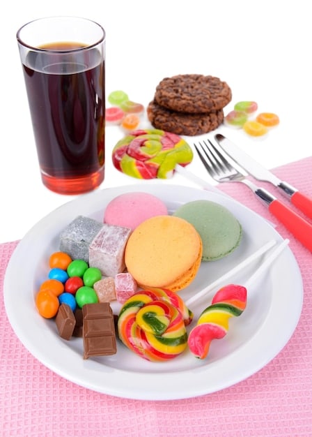 A visually unappealing display of processed foods like sugary drinks, fast food, and packaged snacks, representing foods to avoid for better skin health.