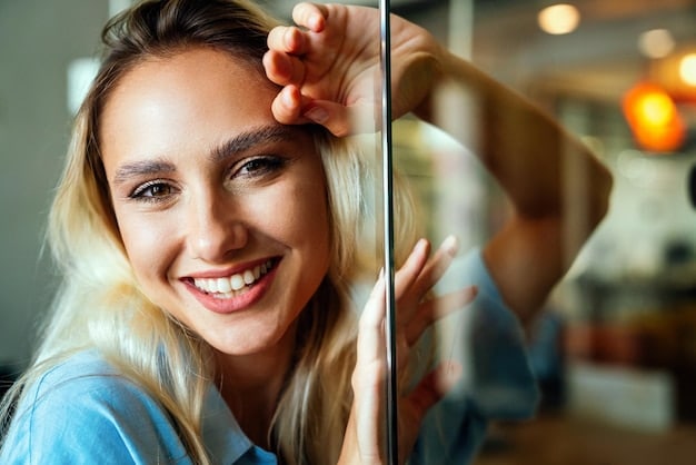 A person looking in a mirror, smiling, with their eyes appearing wide open and refreshed. The expression is one of satisfaction and confidence after eye rejuvenation.