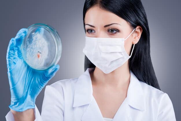 A close-up of a scientist in a lab coat examining a petri dish next to advanced laboratory equipment, symbolizing regenerative medicine and exosome research in facial aesthetics.