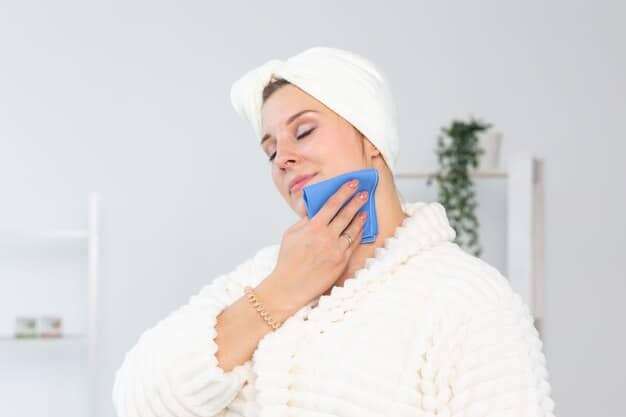 A person gently applying a cold compress to their chin area, illustrating post-operative care for chin augmentation.