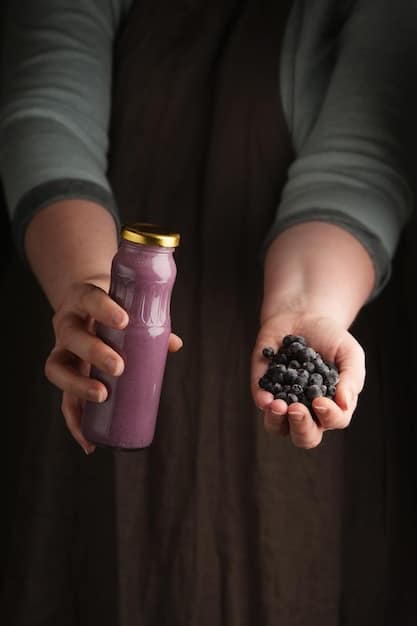 A person holding a resveratrol supplement bottle, reading the label carefully, with a blurred background of fresh grapes and berries on a kitchen counter.
