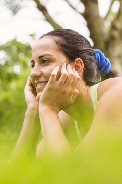 A person applying sunscreen to their face outdoors, with blurred elements of nature in the background, conveying both protection and a healthy lifestyle.