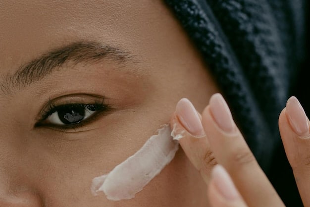 A close-up shot of a hand applying a rich cream moisturizer to a face, with the texture of the cream visible and the skin appearing smooth and soft.
