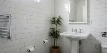 Modern bathroom renovation under $1000 with white tiles and new fixtures
