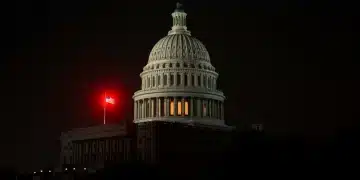 US Capitol in shadows, red light, symbolizing national security threat during shutdown.